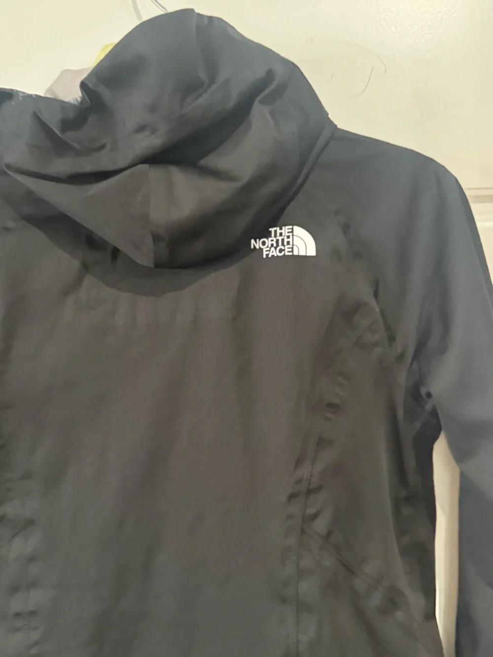 The North Face Black Raincoat with White Zippers and Logo